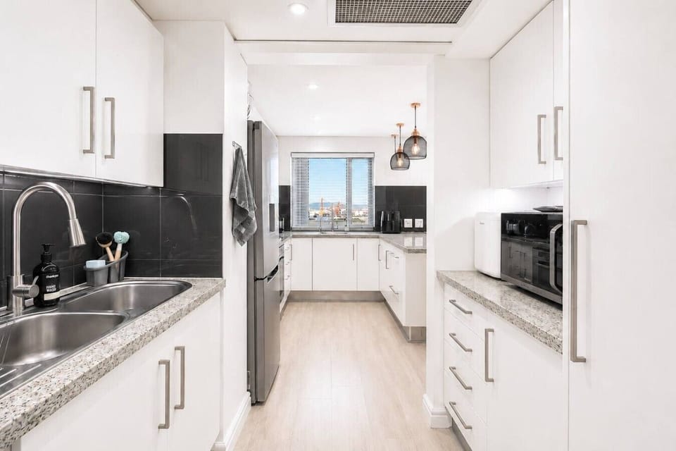 Bright and modern kitchenette with ample storage, quality appliances, and generous counter space, providing everything needed for convenient meal preparation during your stay.