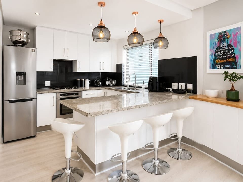 Modern kitchenette with premium finishes, a spacious breakfast bar, and all the essentials for preparing meals, making it a practical and stylish hub for gathering and dining.