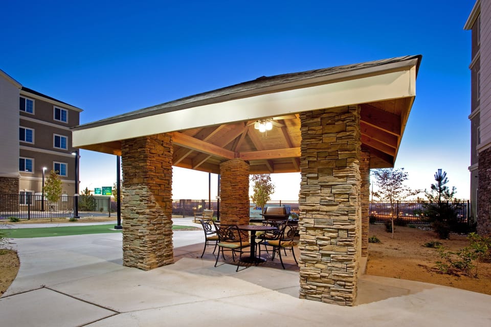 Stone-accented outdoor BBQ patio with seating — fire up the grill for an evening under the New Mexico sky