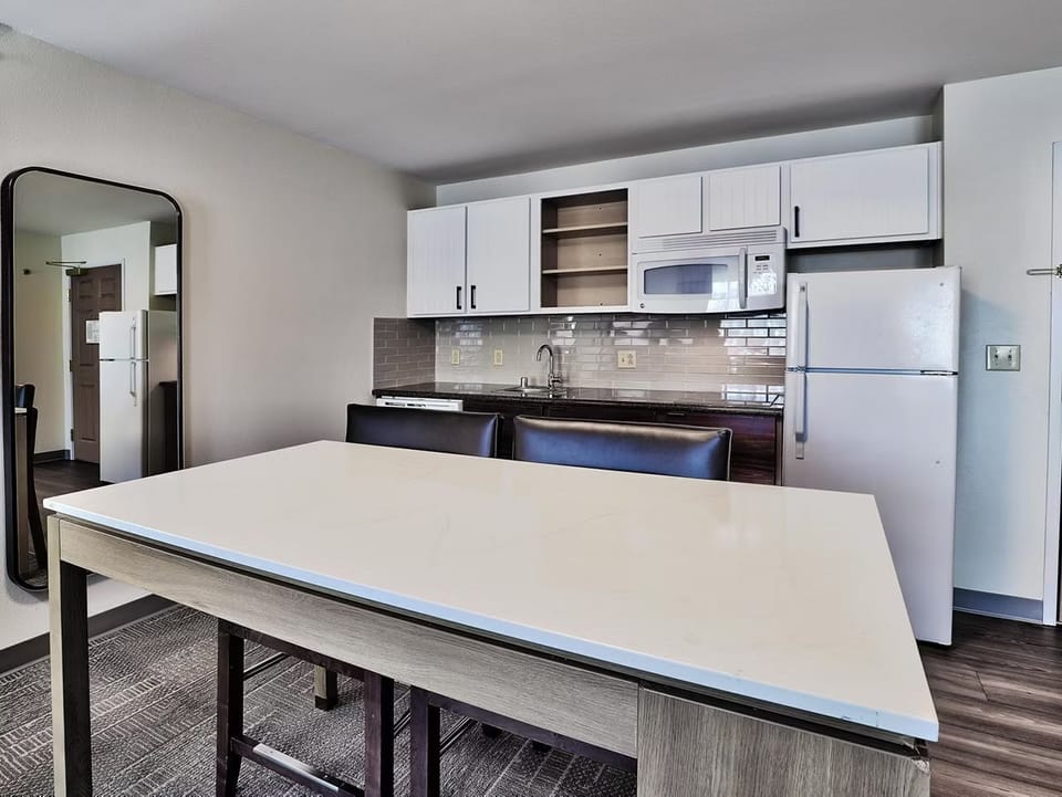 White cabinetry and stainless steel appliances in the fully equipped kitchen — stove, microwave, dishwasher, fridge, and coffee maker included