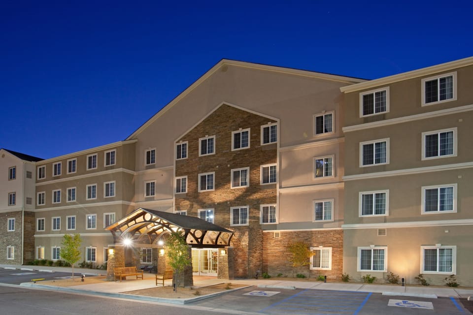 Warm-lit exterior at dusk — the property sits one mile from ABQ Sunport Airport with on-site parking