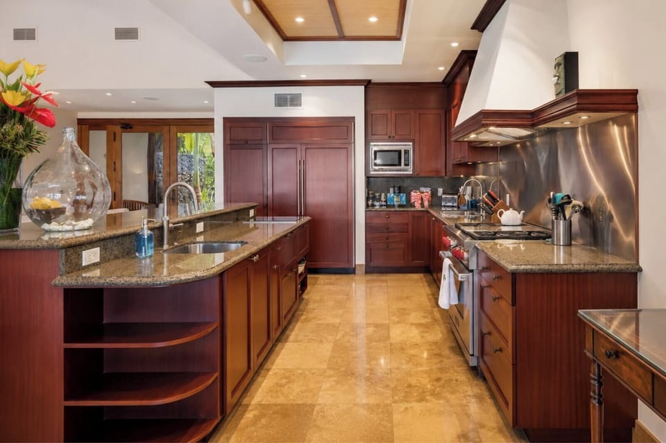 Dark wood cabinetry and stainless appliances give the kitchen a refined, polished feel