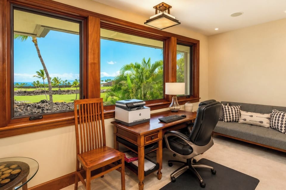 The den features a comfortable seating area in addition to the private workspace