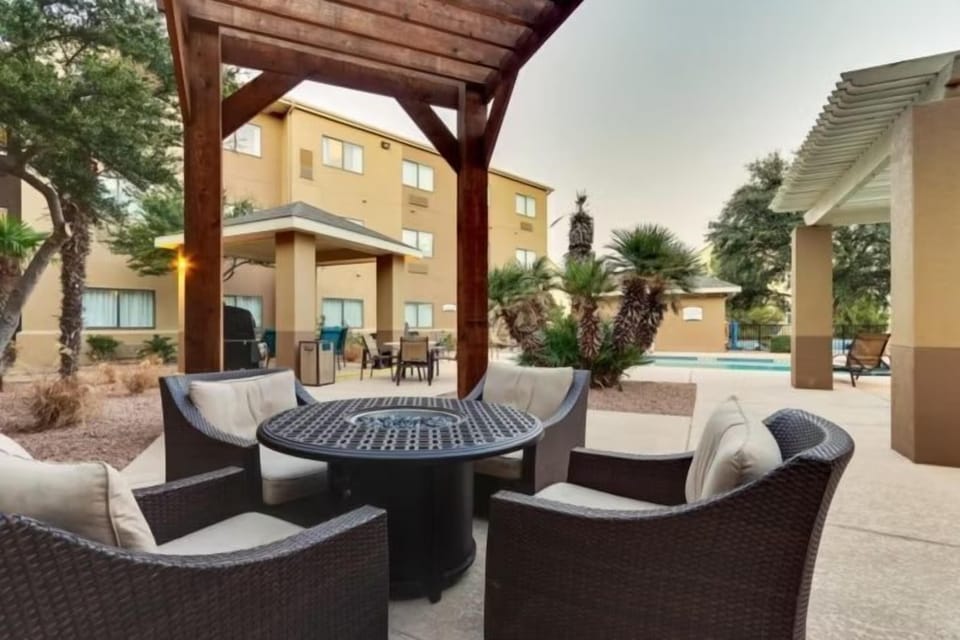 Outdoor courtyard seating area with wicker chairs and desert landscaping.