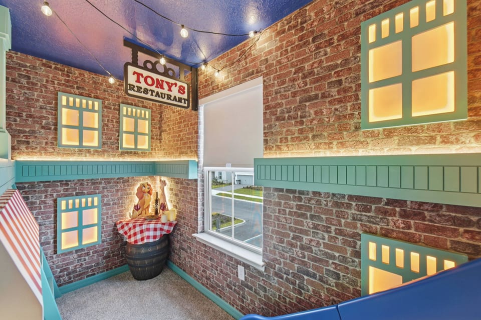 Enjoy a soccer themed gaming nook with framed jerseys, stadium wall art, arcade controls, LED lighting, soccer ball decor, and a colorful seat, creating a fun space for vacation entertainment.