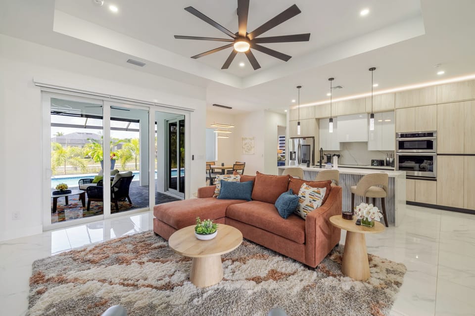 Bright open-concept living room with plush seating that flows into the kitchen and dining area.