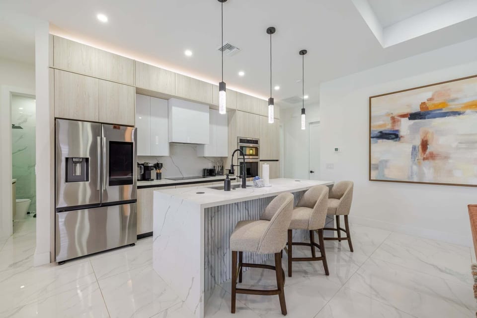 Modern kitchen with a large island, quartz counters, and stainless steel appliances.