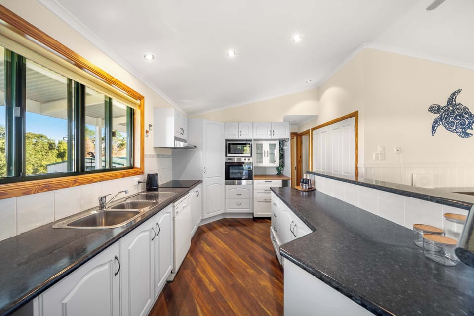 Whether you're preparing a leisurely breakfast or a family feast, the spacious kitchen is equipped with an oven, cooktop, microwave, dishwasher, full-sized fridge and generous bench space, all bathed in beautiful natural light.