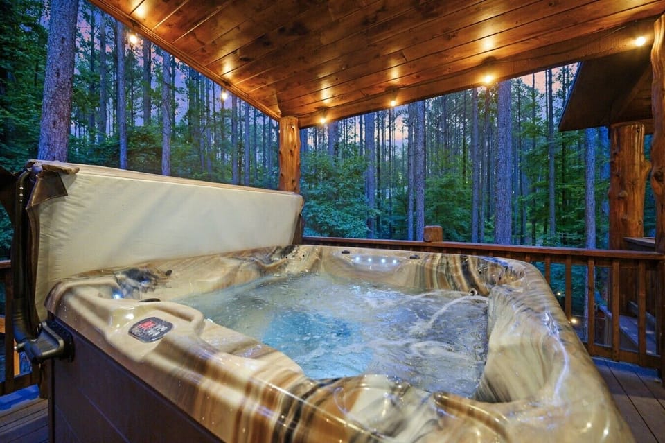Blue LED jets, warm timber overhead, and an open forest — hot tub relaxation at its finest.