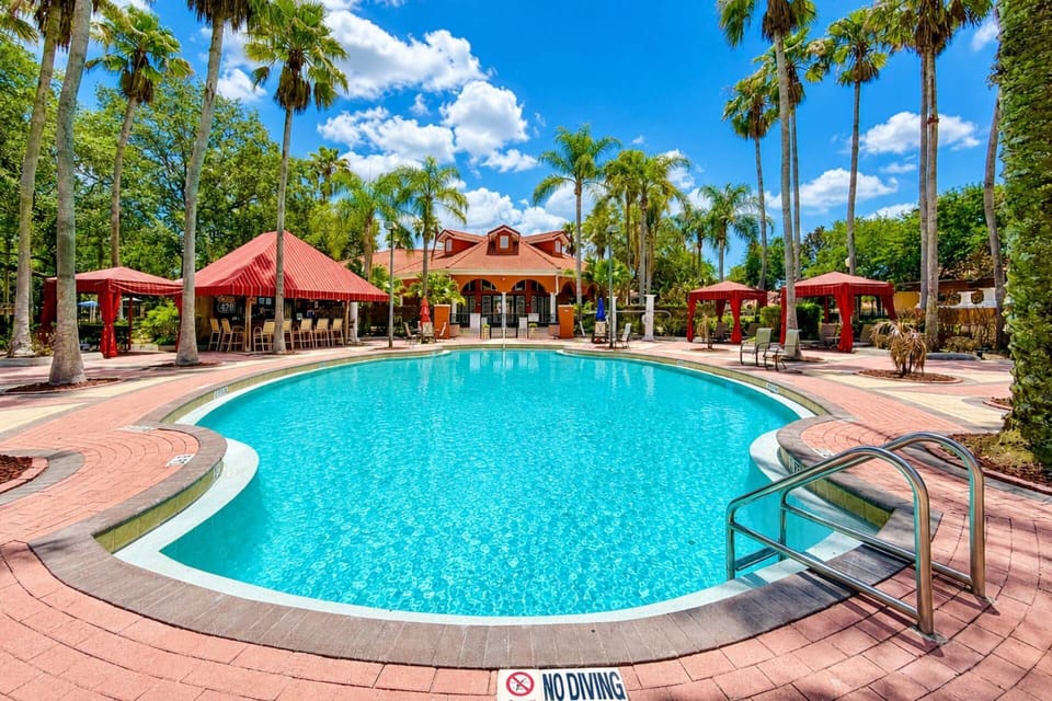 Large Resort Pool (Free access) with shaded cabanas, tall palm trees, Tiki Bar and more!