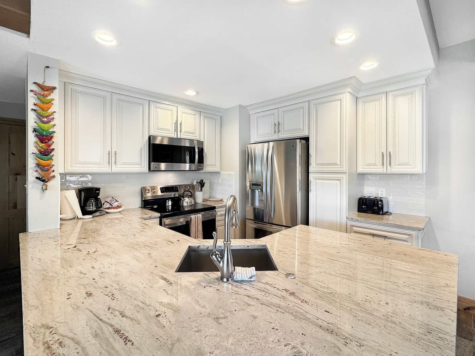 Open kitchen with bar seating | Listed with @BookTraverse