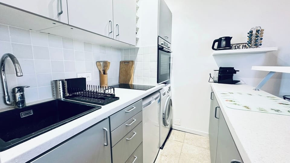 Fully equipped kitchen  Functional kitchen with induction cooktop, oven, microwave, refrigerator, and washing machine