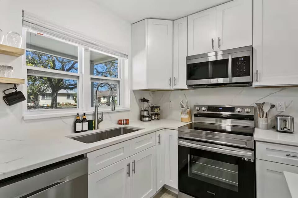 Modern kitchen with everything you need—microwave, oven, blender, toaster, and more.