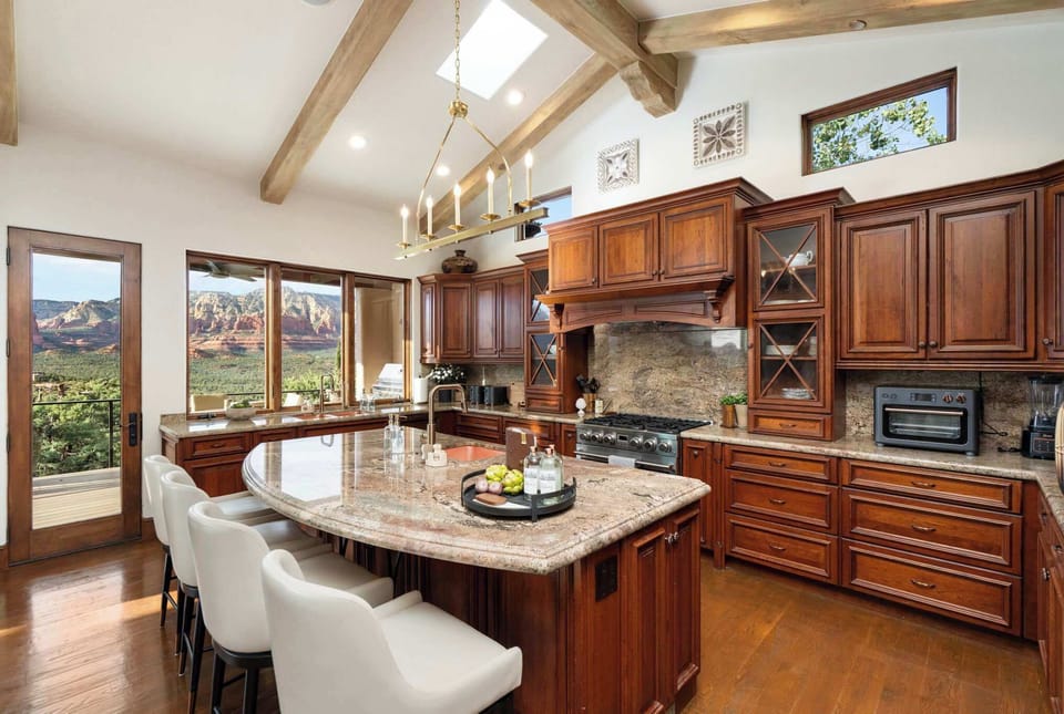 The chef's kitchen combines premium appliances, generous prep space, and stunning red rock views, creating an inspiring setting for meals, gatherings, and celebrations.