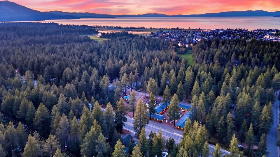 Stunning wide aerial panorama of the entire forested neighborhood bordering the shoreline.