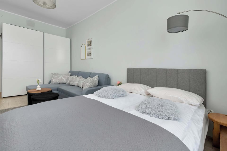 A bright bedroom with a double bed and simple furnishings. Neutral colors give the space a relaxing feel.