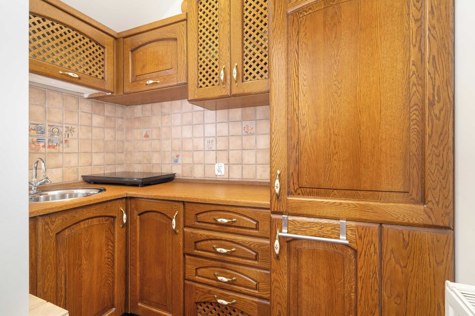 Another kitchen angle highlighting custom wooden cupboards, drawers, and a built-in countertop workspace.