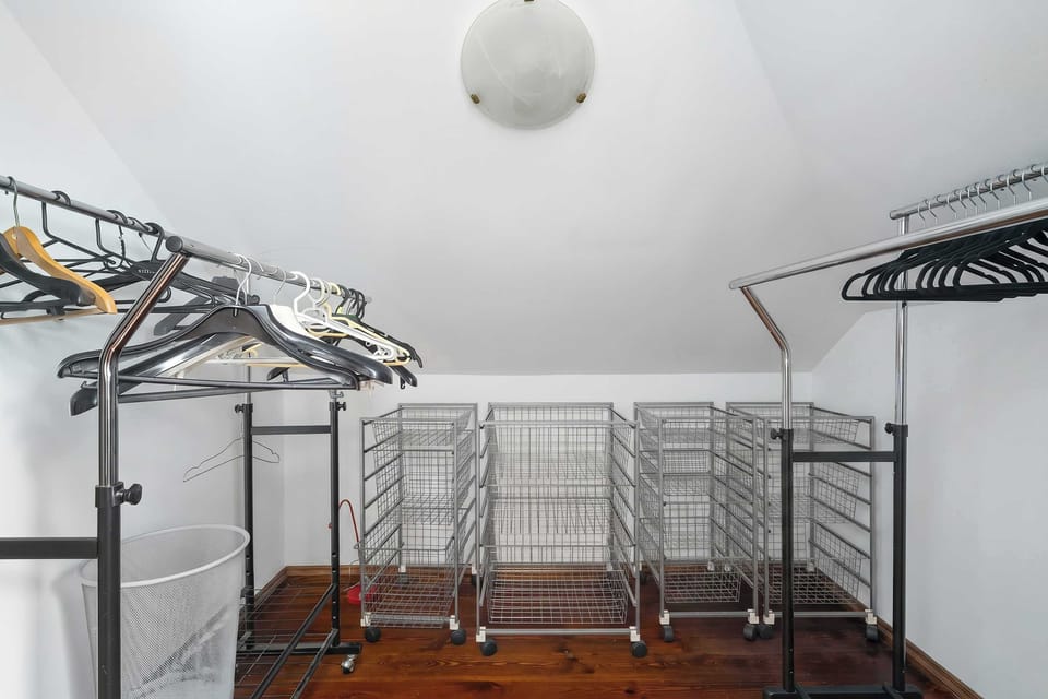 A walk-in wardrob with open shelving, hanging rails, and storage racks for clothing.