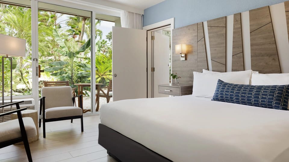 Drift off beside tropical greenery and sunlit patio doors.