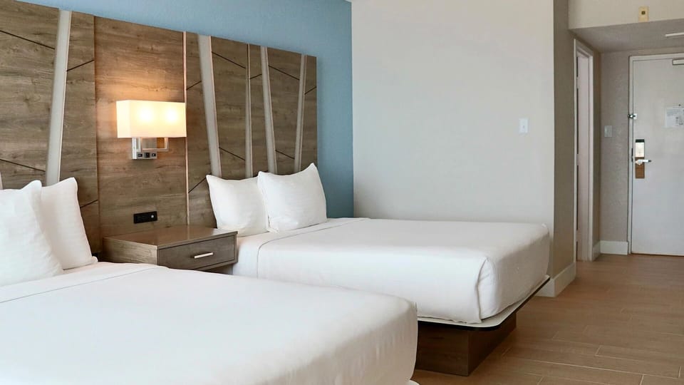 Drift off in crisp linens beneath warm, modern lighting.