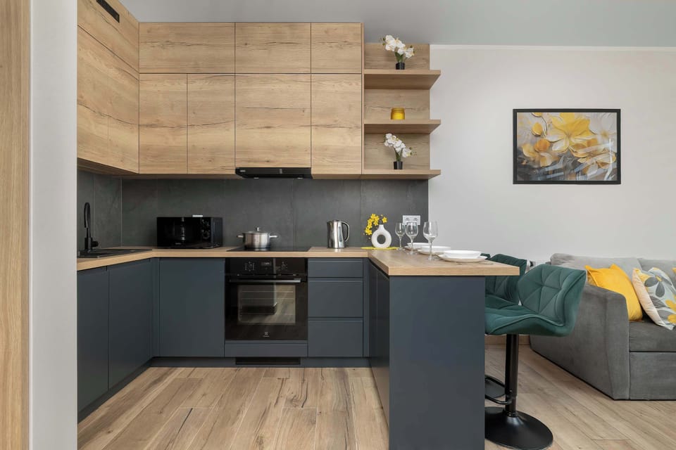 A stylish kitchen with dark cabinetry and wooden accents. The space is fully equipped for preparing meals during your stay.
