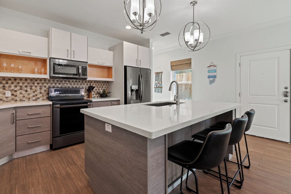 Beautiful open kitchen featuring abundant cabinetry, quartz countertops, and modern finishes