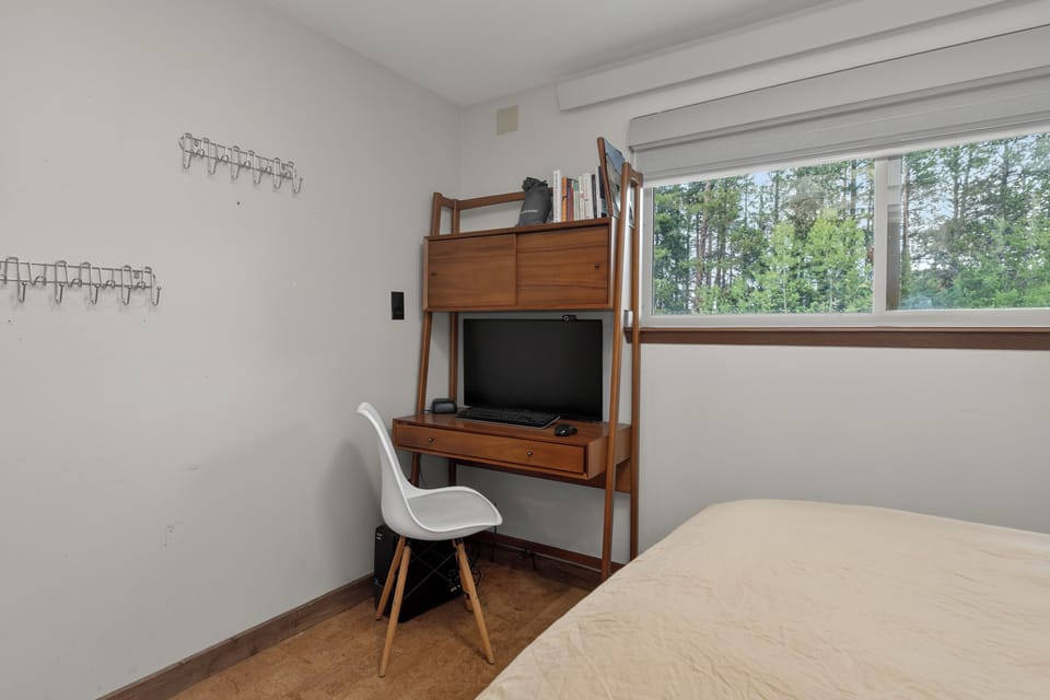 Your peaceful retreat features a cozy workspace beside your bed, with serene forest views to inspire your mornings and help you unwind each evening.