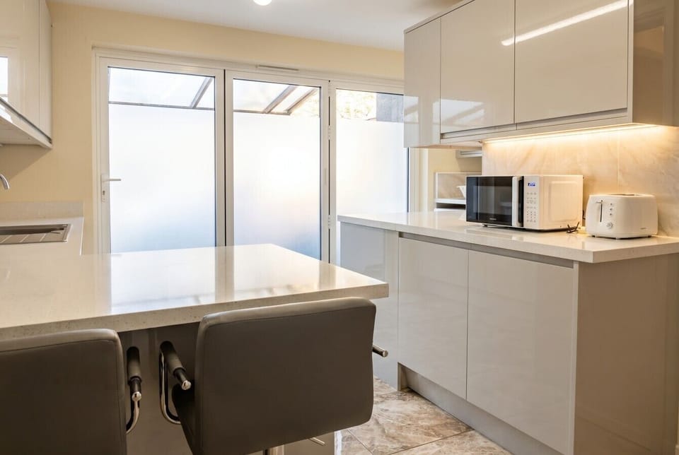 Gleaming kitchen with microwave, toaster and bright bi-fold doors.