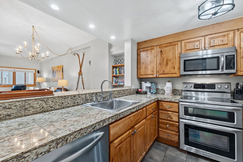 Your gourmet kitchen awaits with gleaming granite counters, warm wood cabinetry, and top-tier stainless steel appliances—perfect for whipping up après-ski meals or morning coffee.