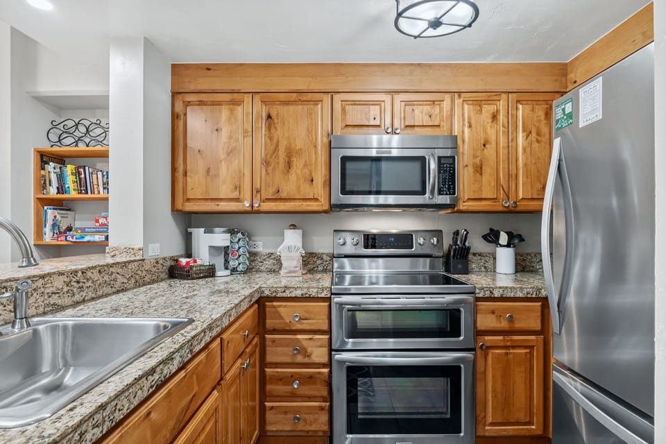 Your fully equipped kitchen features granite countertops, stainless steel appliances, and warm wood cabinetry—perfect for preparing home-cooked meals during your stay.