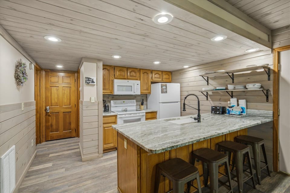 Your fully equipped kitchen features granite countertops, modern appliances, and a breakfast bar with seating—perfect for preparing meals and gathering together.