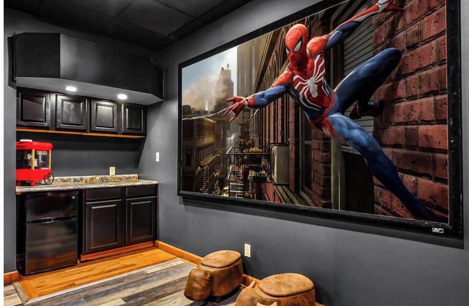 Settle in for your own private movie marathon with this cinema-style theater room featuring a massive screen and cozy seating, plus convenient kitchenette access.