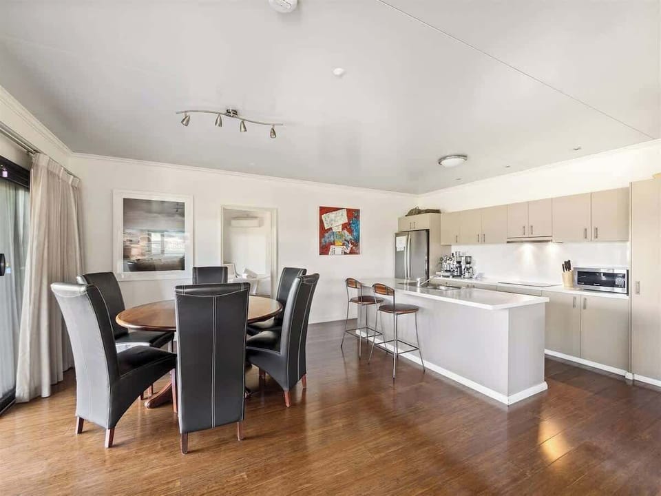 Framed by natural light and peaceful outlooks, the dining area invites long meals and easy conversation, with plenty of room for family and friends to come together over local produce and home-cooked favourites.