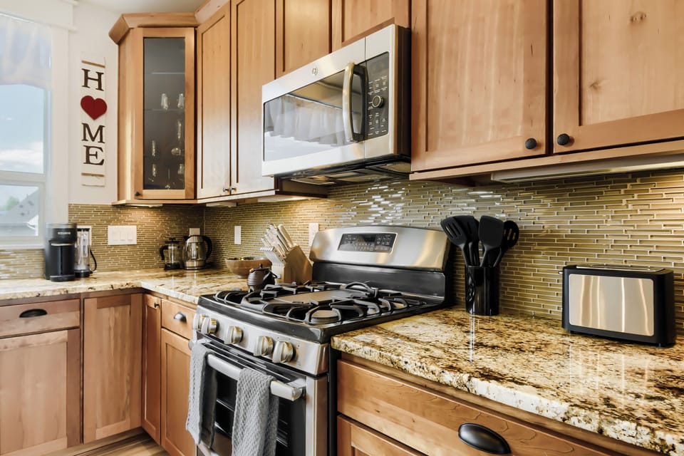 Your fully-equipped kitchen awaits with warm maple cabinetry, gleaming granite counters, and modern appliances—everything you need to prepare meals just the way you like.