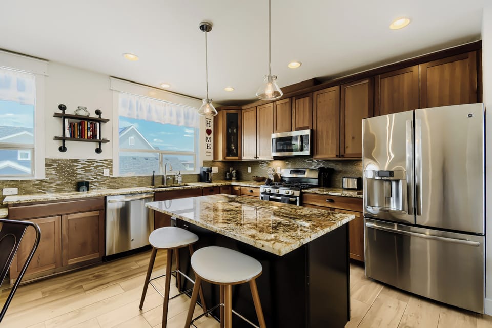 Picture yourself preparing meals in this bright, fully equipped kitchen with granite counters, modern appliances, and stunning water views through the windows—your home away from home awaits.