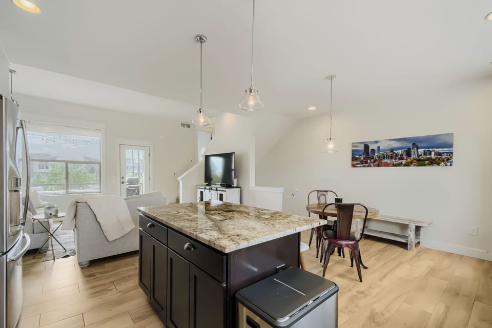 Light-filled living space where your group can gather around the granite island, relax on the sofa, or enjoy meals together at the dining table—all under elegant pendant lighting.