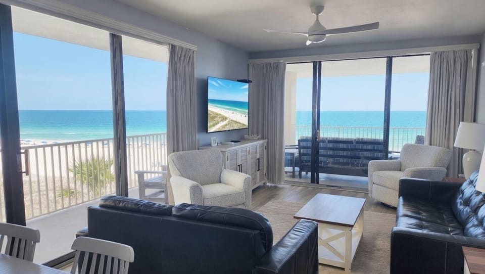 Bright oceanfront living room with private balcony and stunning beach views