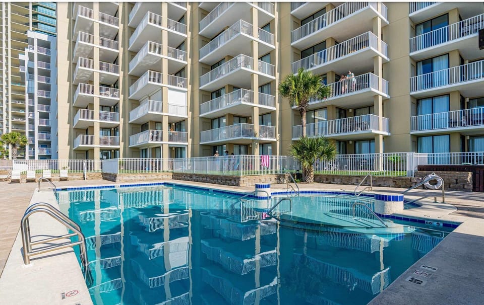 Resort-style pool with sunny deck and high-rise balcony views