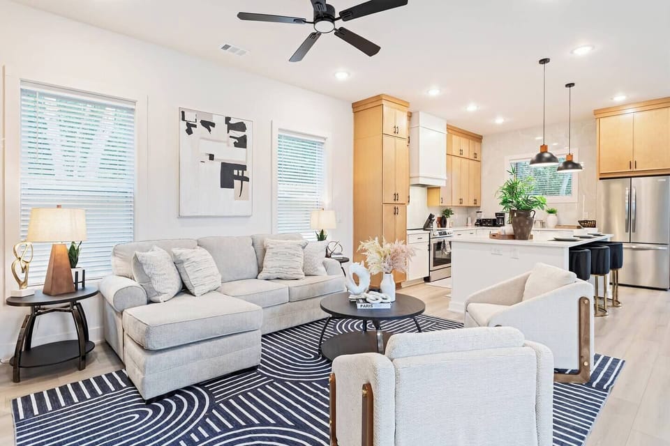 Bright, modern living room with designer details and an open flow to the kitchen. Perfect for relaxing after exploring Atlanta’s top attractions. Enjoy plush seating, natural light, and warm wood cabinetry for a cozy, upscale stay.