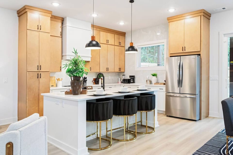 Cook and connect in this beautiful chef’s kitchen featuring stainless steel appliances, quartz countertops, and gold-accented bar stools. Perfect for morning coffee, dinner gatherings, or late-night snacks after exploring Atlanta.