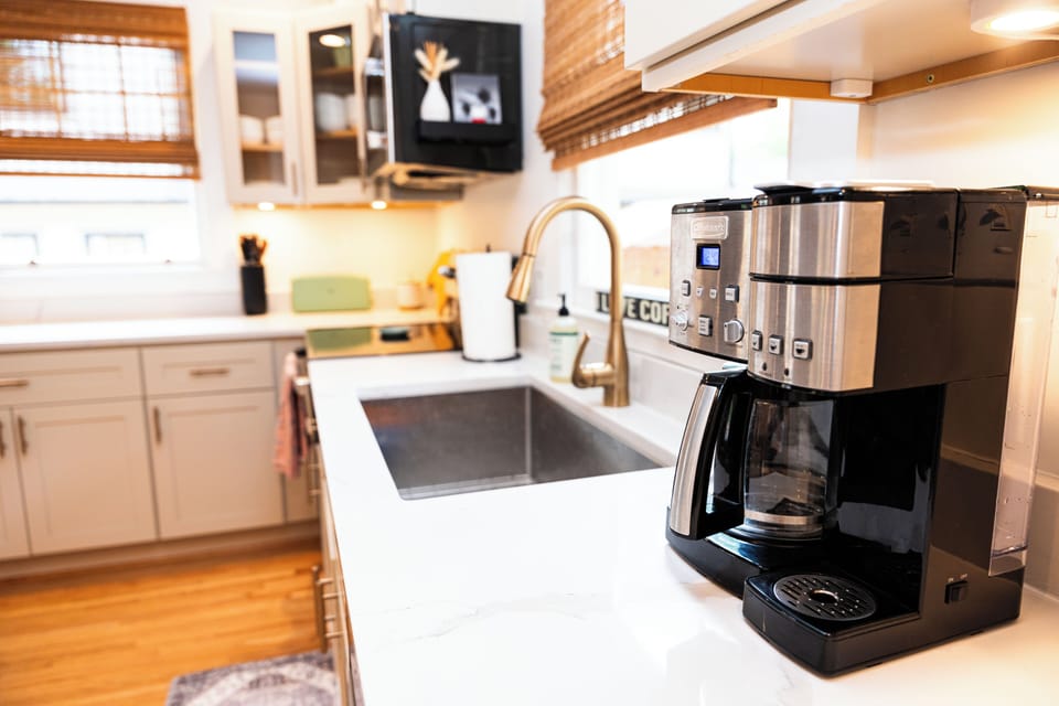 Kitchen with farm sink and coffee pot. 