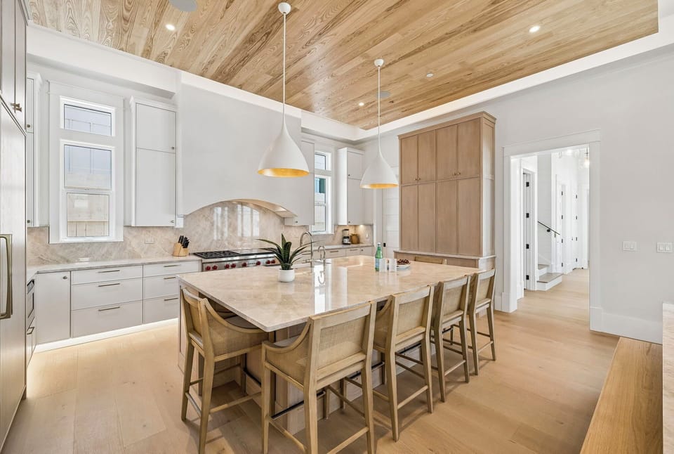 You'll love the spacious kitchen with its stunning wood-grain ceiling, gleaming marble island, and designer pendant lights—perfect for gathering with loved ones while preparing meals together.