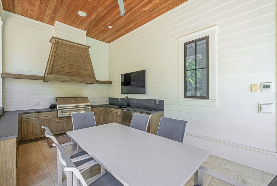 Picture yourself grilling under soaring wood ceilings while your loved ones gather around this spacious dining table, sharing stories and laughter in your own open-air culinary retreat.