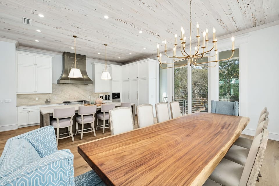 Step into an inviting open-concept space where a stunning live-edge dining table anchors the room. Your kitchen features sleek white cabinetry, modern appliances, and a large island—perfect for creating memorable meals together.