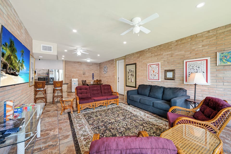 Relax in your spacious living area with comfortable seating, ceiling fans for cool breezes, and easy access to the kitchen—perfect for unwinding after a day of adventure.