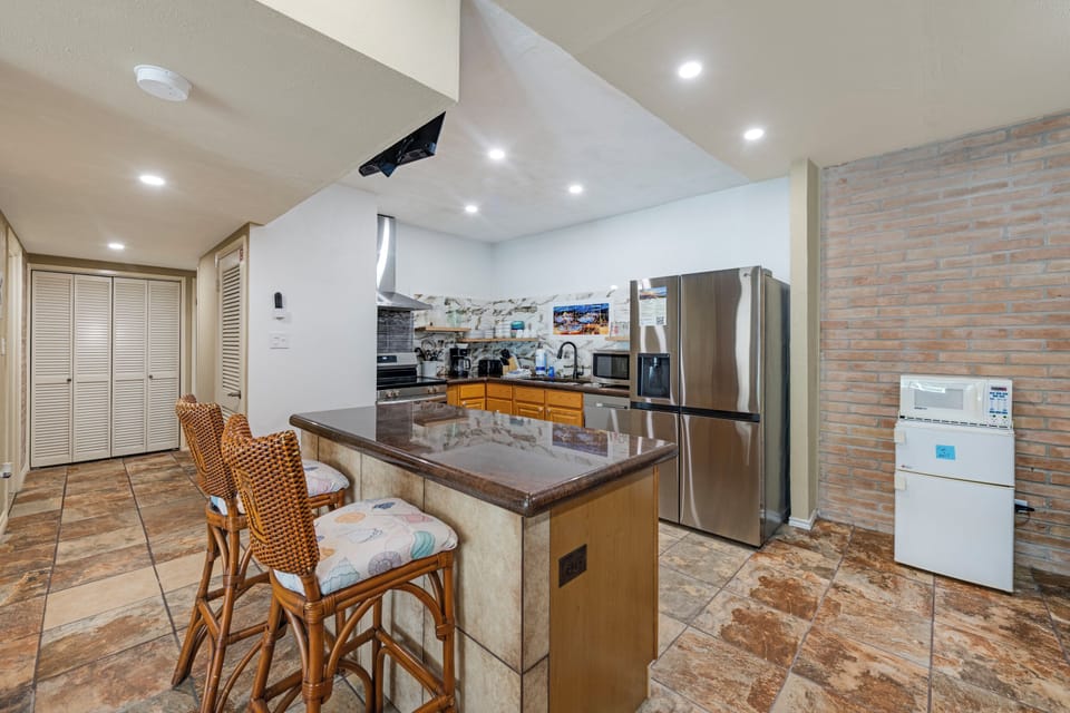 Your fully equipped kitchen features stainless steel appliances, granite countertops, and a convenient breakfast bar with seating—perfect for preparing meals and gathering with loved ones.