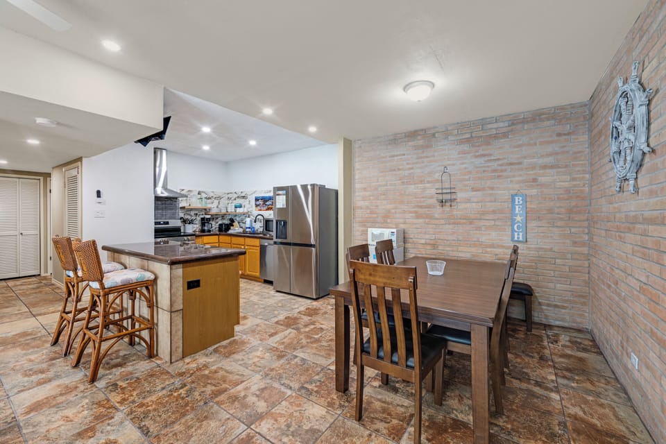 Cook your favorite meals in this fully equipped kitchen, then gather around the dining table for quality time. The coastal decor and open layout create a relaxed, beachy vibe for your stay.