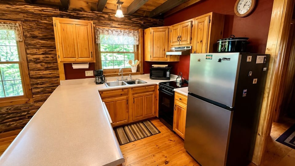 Rustic cabin kitchen with modern appliances, ample counter space, and natural wood finishes.