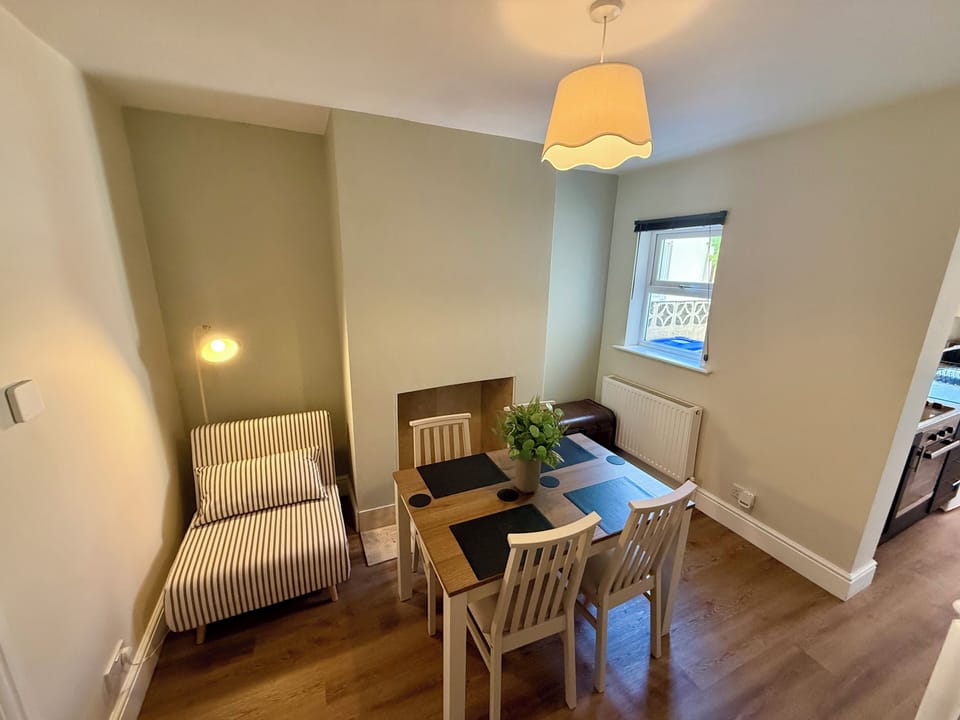 Bright, cozy dining space with seating for four and a relaxing reading nook