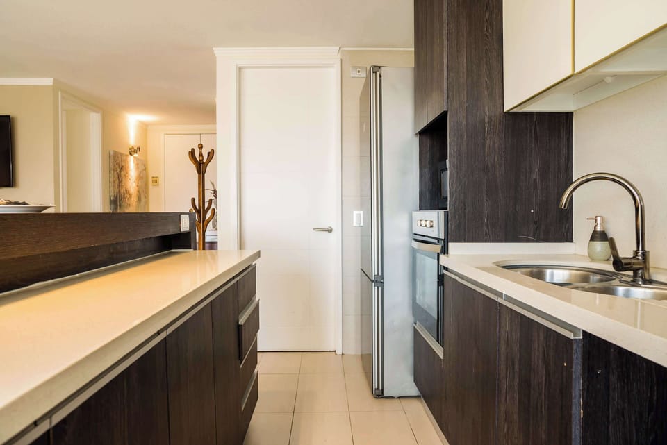 Sleek and modern kitchen with stainless steel appliances and elegant dark wood cabinetry, perfect for culinary enthusiasts.